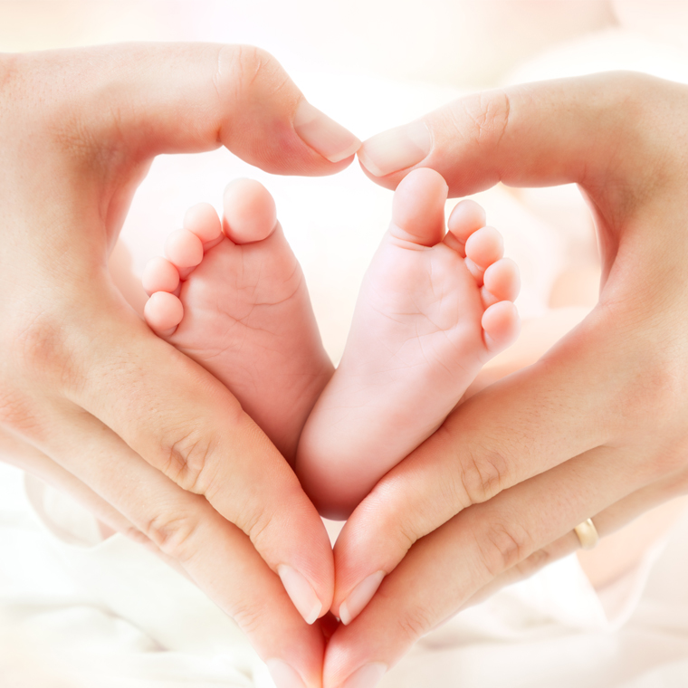 baby's feet and mom's hands in heart shape